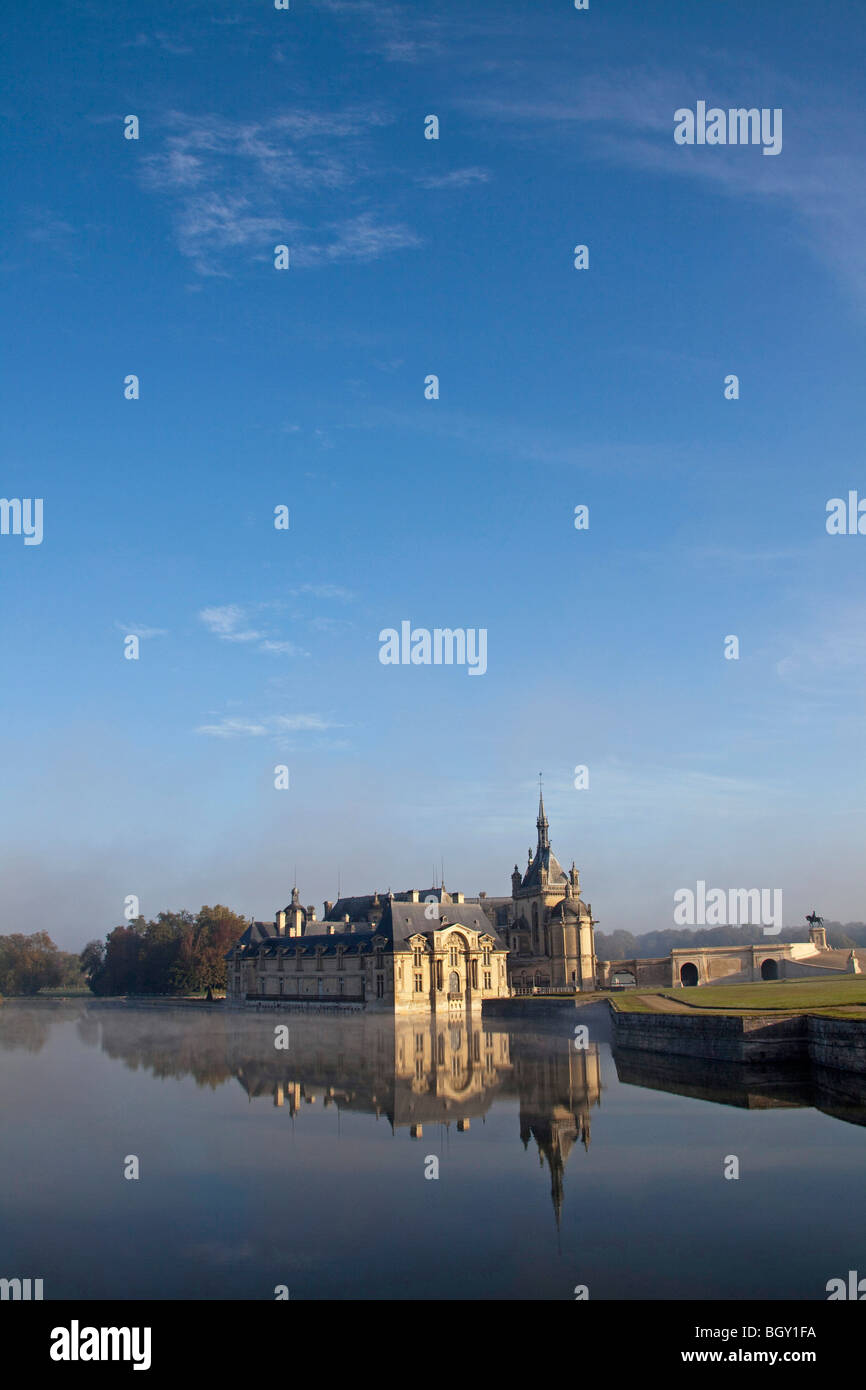 Château de Chantilly, Oise Frankreich. Wasser Reflexion atmosphärischen Sonnenlicht, blauen Morgenhimmel. Vertikale 100379 Chantilly Stockfoto