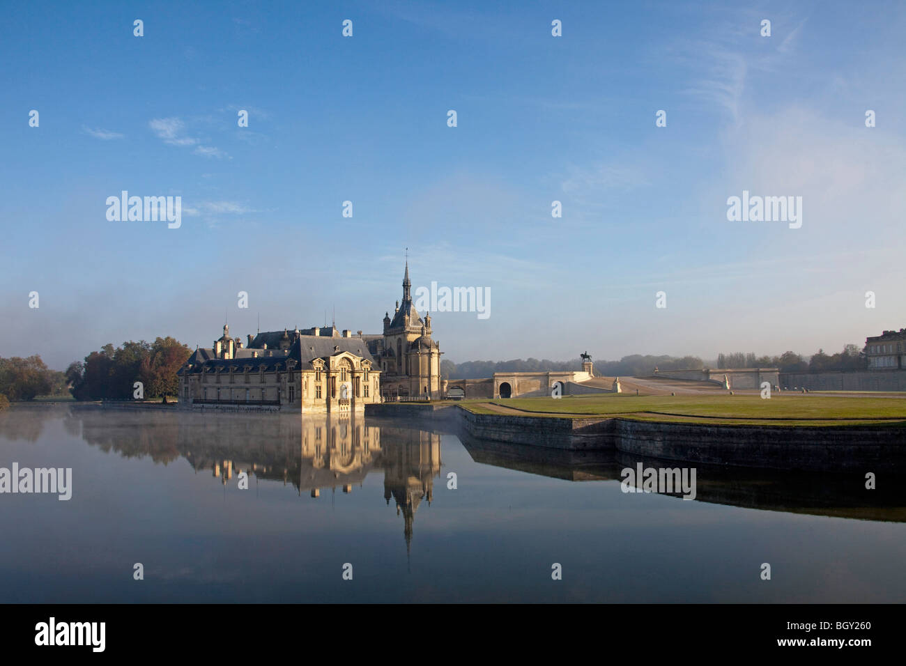 Château de Chantilly, Oise Frankreich. Wasser Reflexion atmosphärischen Sonnenlicht, blauen Morgenhimmel. Horizontale 100380 Chantilly Stockfoto