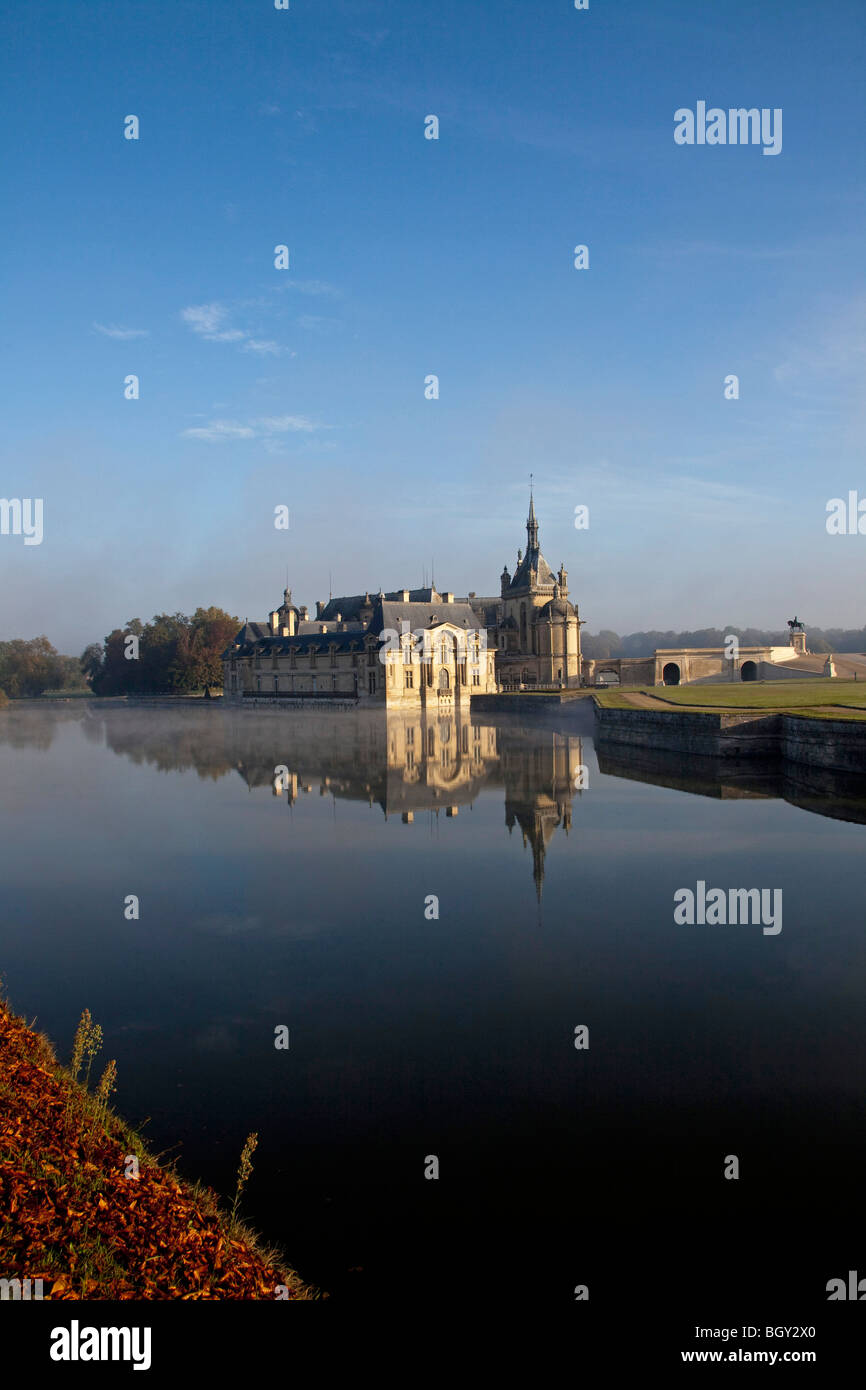 Château de Chantilly, Oise Frankreich. Wasser Reflexion atmosphärischen Sonnenlicht, blauen Morgenhimmel. Vertikale 100378 Chantilly Stockfoto