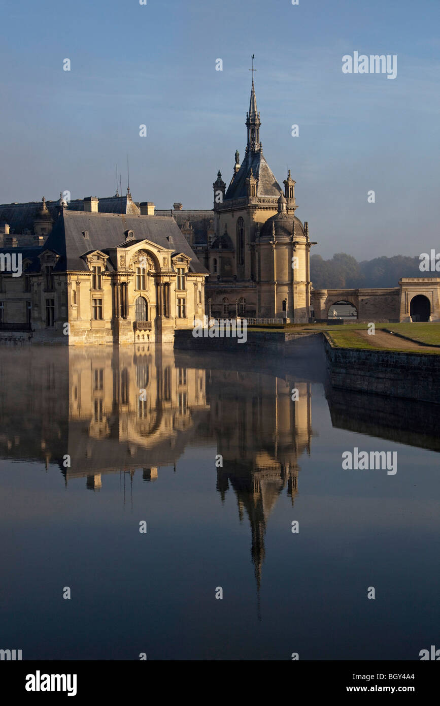 Château de Chantilly, Oise Frankreich. Wasser Reflexion atmosphärischen Sonnenlicht, blauen Morgenhimmel. Vertikale 100376 Chantilly Stockfoto