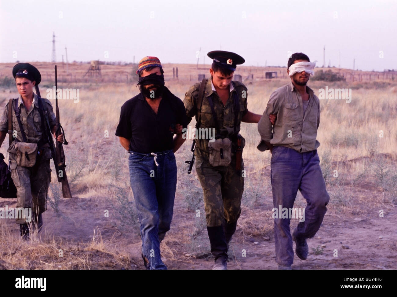 Russische Soldaten Escort erfasst und mit verbundenen Augen tadschikischen und afghanische Pistole Schmuggler zu ihrer Basis in Pyandsh, Tadschikistan. Stockfoto