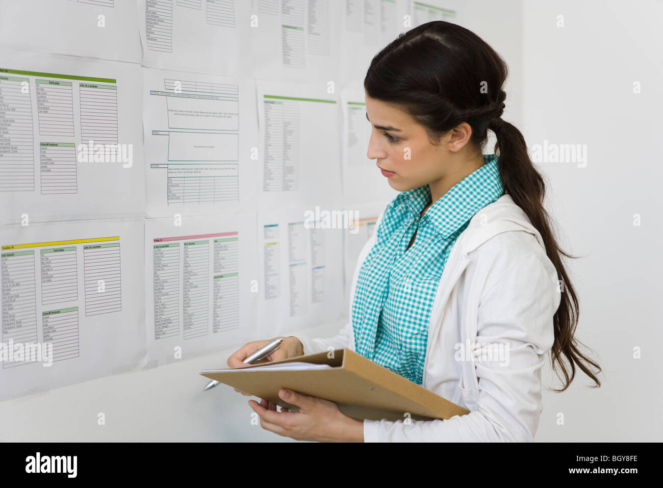Weibliche College-Student betrachten Informationen am schwarzen Brett veröffentlicht Stockfoto