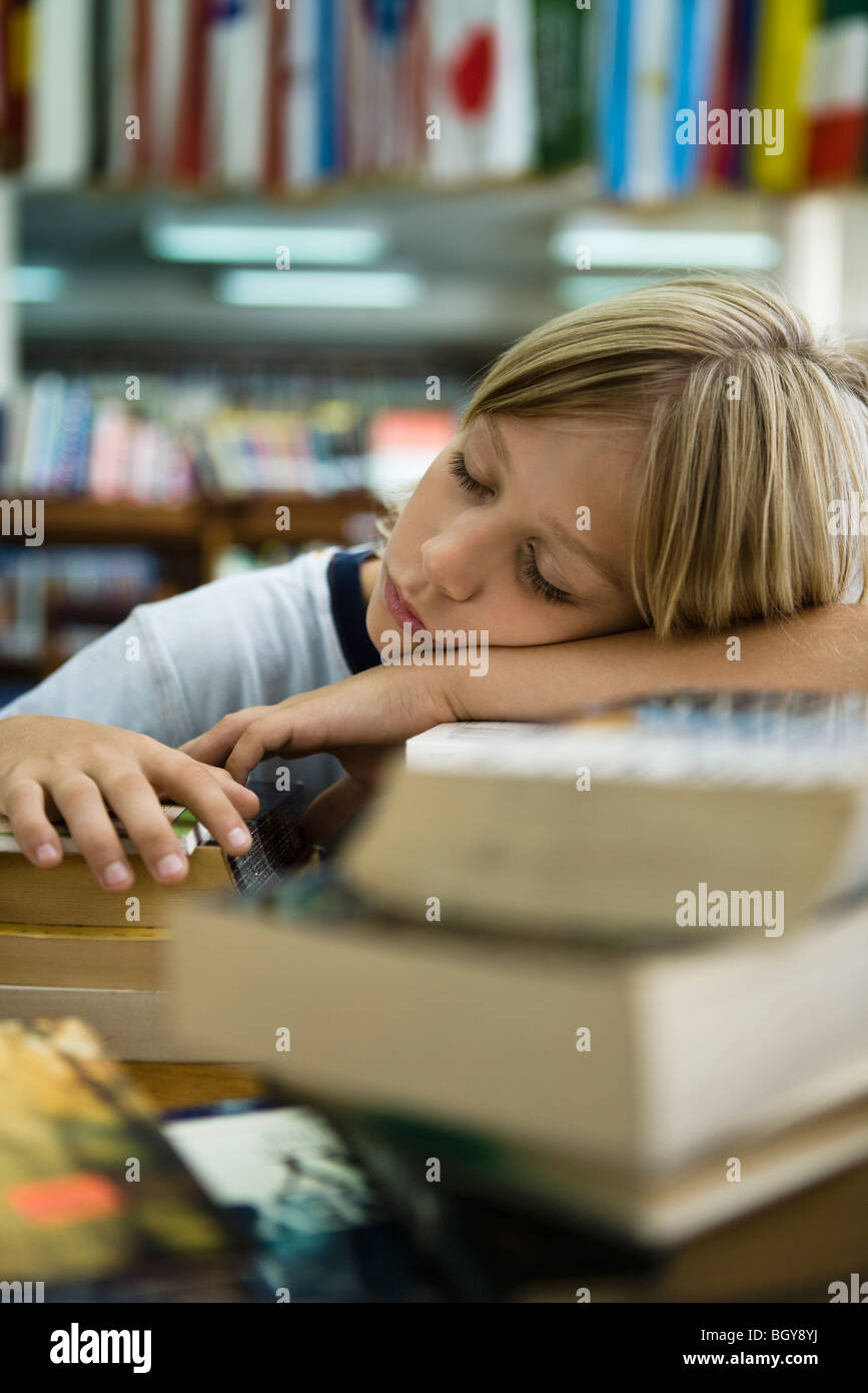 Junge Kopf ruht, auf Arme einschlafen in Bibliothek Stockfoto