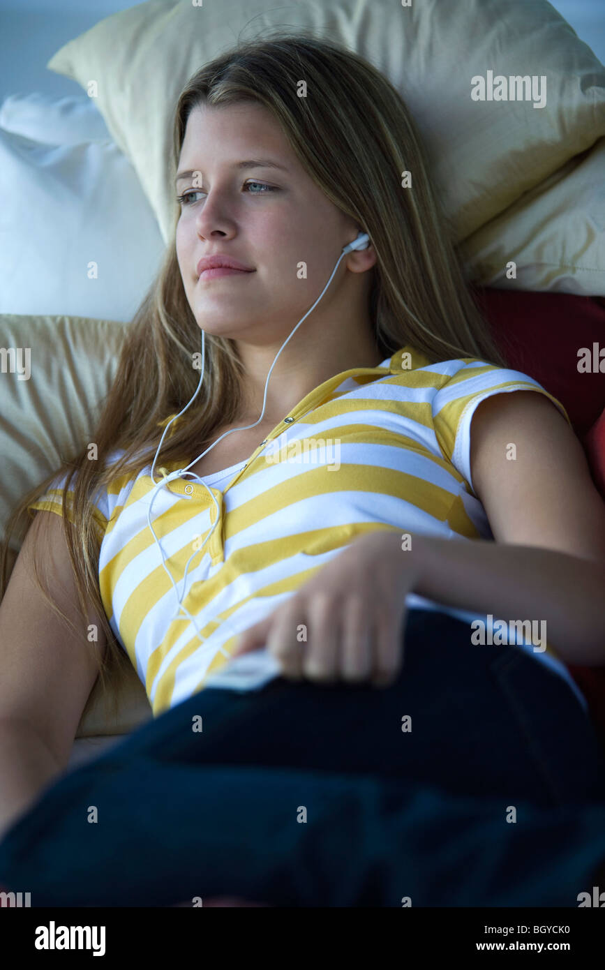 Junge Frau liegend auf dem Bett, anhören von MP3-player Stockfoto
