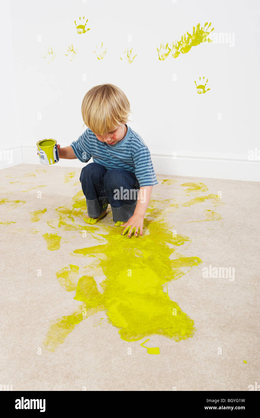 Junge spritzende Farbe auf Teppich Stockfoto