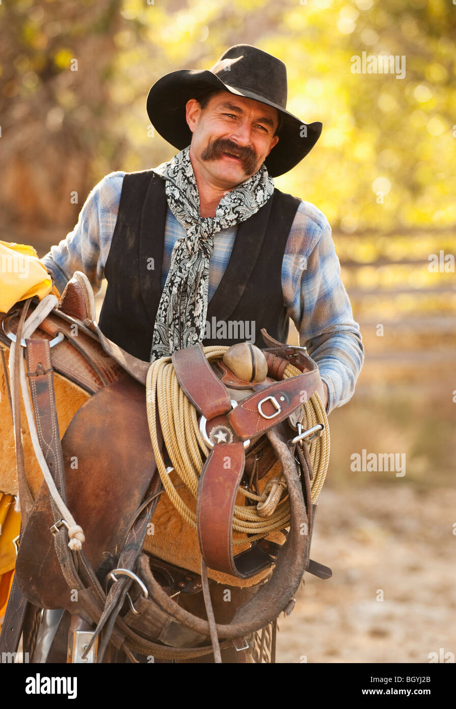 Cowboy-Holding-Sattel Stockfoto