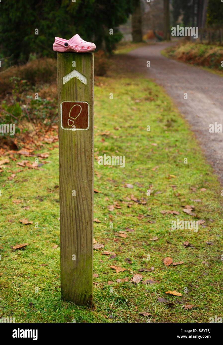 Childs Schuh platziert auf einem Fußweg-Indikator. Stockfoto