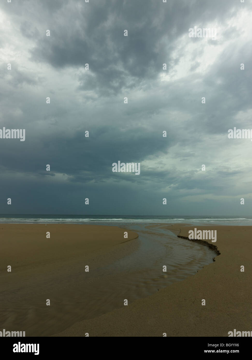 Eine Strand-Stream-Steckdose fließt in das Meer und die böse Wetter. Corrimal Beach, New South Wales Australien Stockfoto