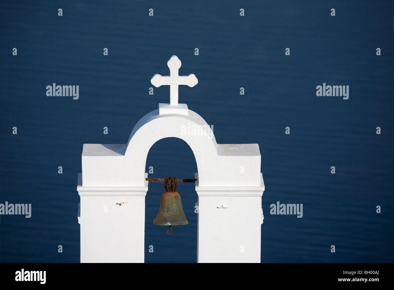 St. Gerasimos Christian Church Glockenturm und Kreuz vor blauem Hintergrund des Mittelmeers in Firostefani auf der Insel Santorini, Griechenland Stockfoto