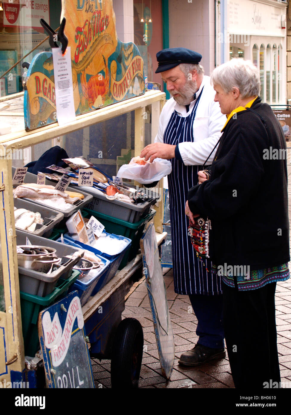 Dan der Fische-Mann, einige Fische an einem Kunden verkaufen. Stockfoto