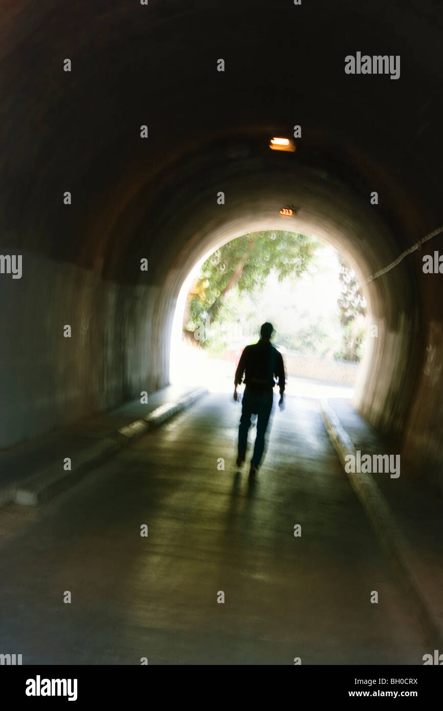 Geheimnisvolle verschwommene männliche Figur im Tunnel zu Fuß. Stockfoto
