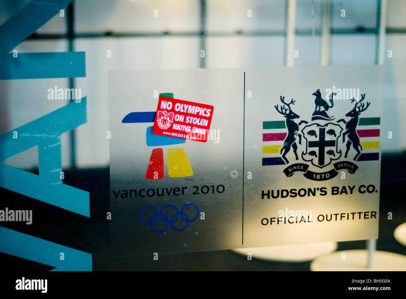 Aufkleber "keine Olympischen Spiele auf gestohlenem native Land" besagt für Spitze der Olympischen Fahne Hudson Bay Store, Vancouver Stockfoto