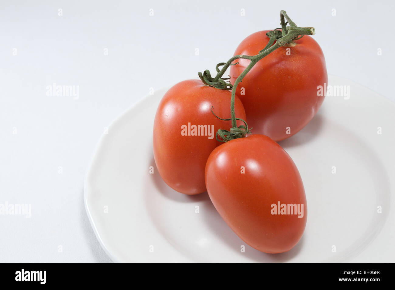 Drei Roma-Tomaten auf Teller. Still-Leben. Stockfoto