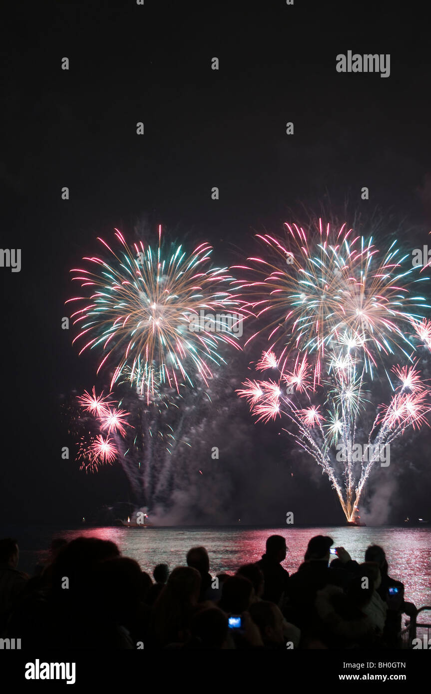 Nett, Frankreich, große Menschenmenge, von hinten in Silhouette, Faschingsfeuerwerk auf dem Mittelmeer, Nachtkarneval frankreich Stockfoto