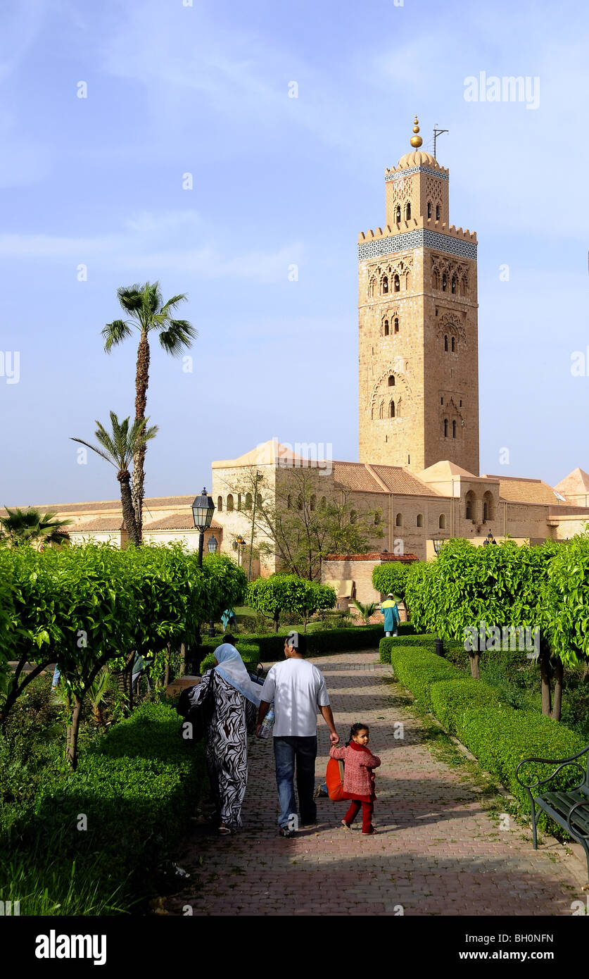 Familie in einem Park vor das Minarett der Koutoubia-Moschee, Marrakesch, Süden von Marokko, Marokko, Afrika Stockfoto
