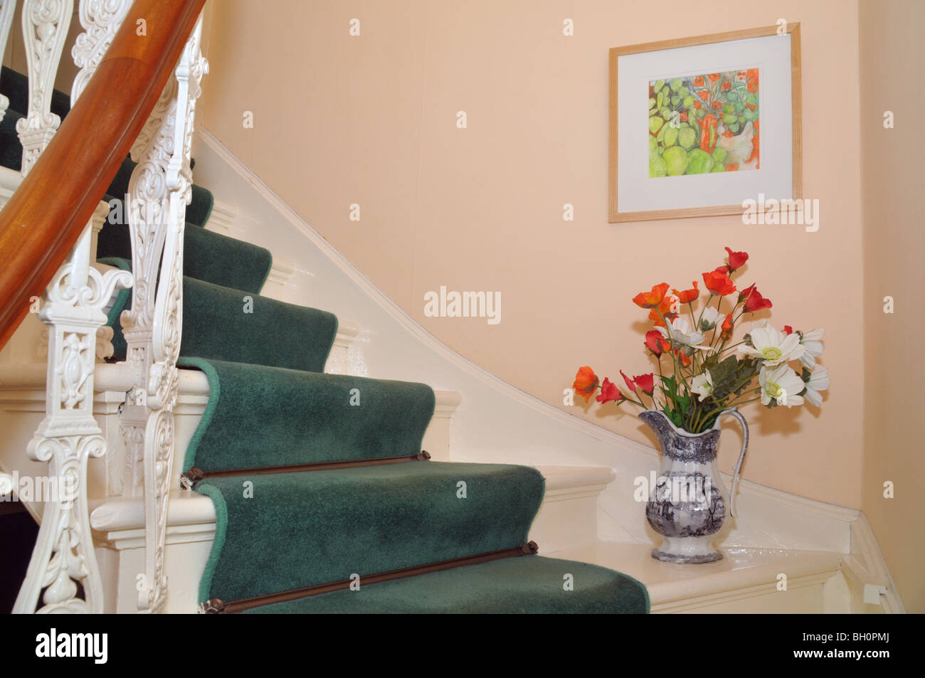 Geländer und Teppichboden Treppenhaus mit floralen Ornamenten und hängenden Bild. Stockfoto