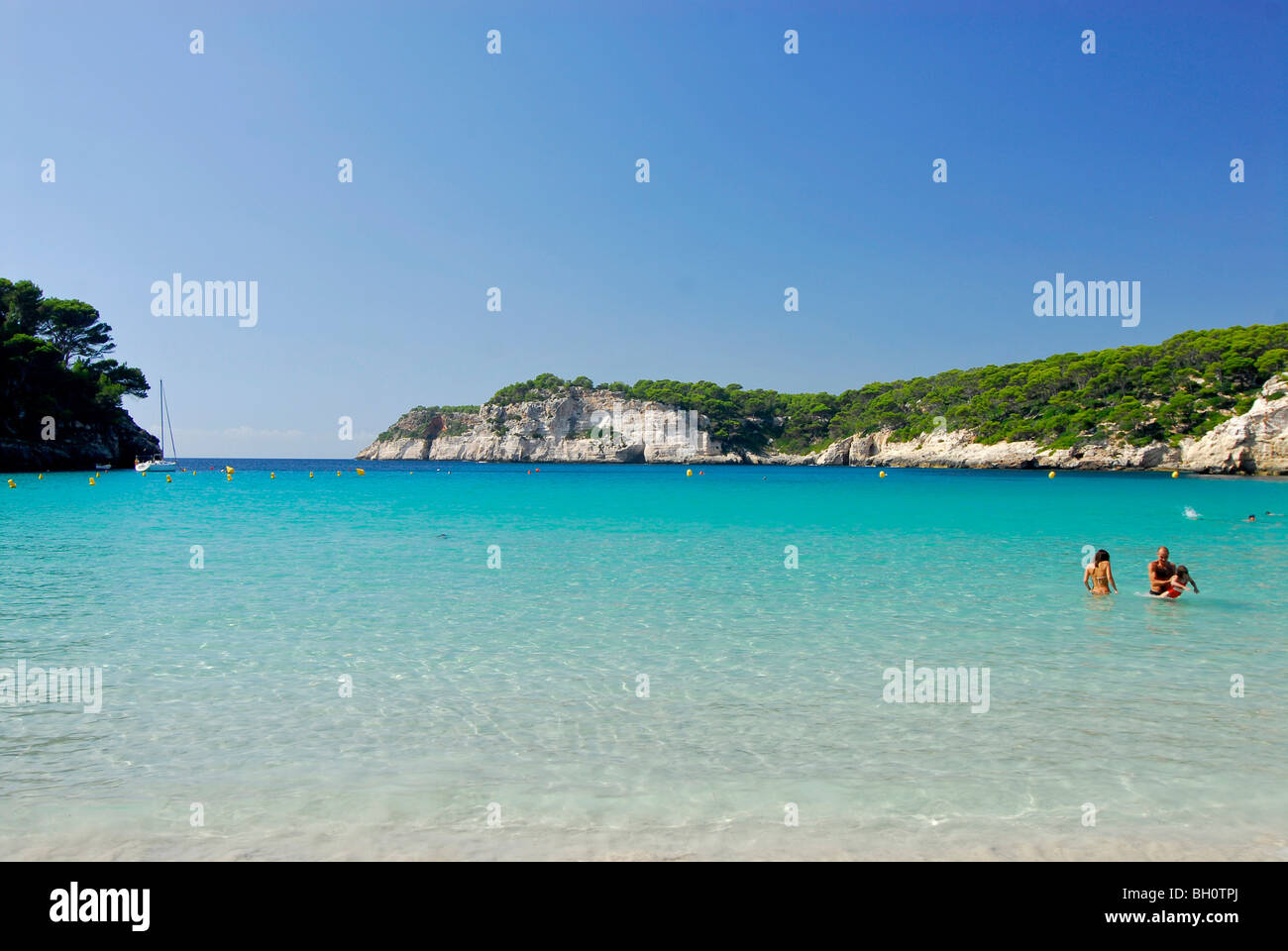 Menschen, die Schwimmen im Meer, Sandstrand und türkisblauem Meer in Cala Galdana, Menorca, Balearen, Spanien Stockfoto