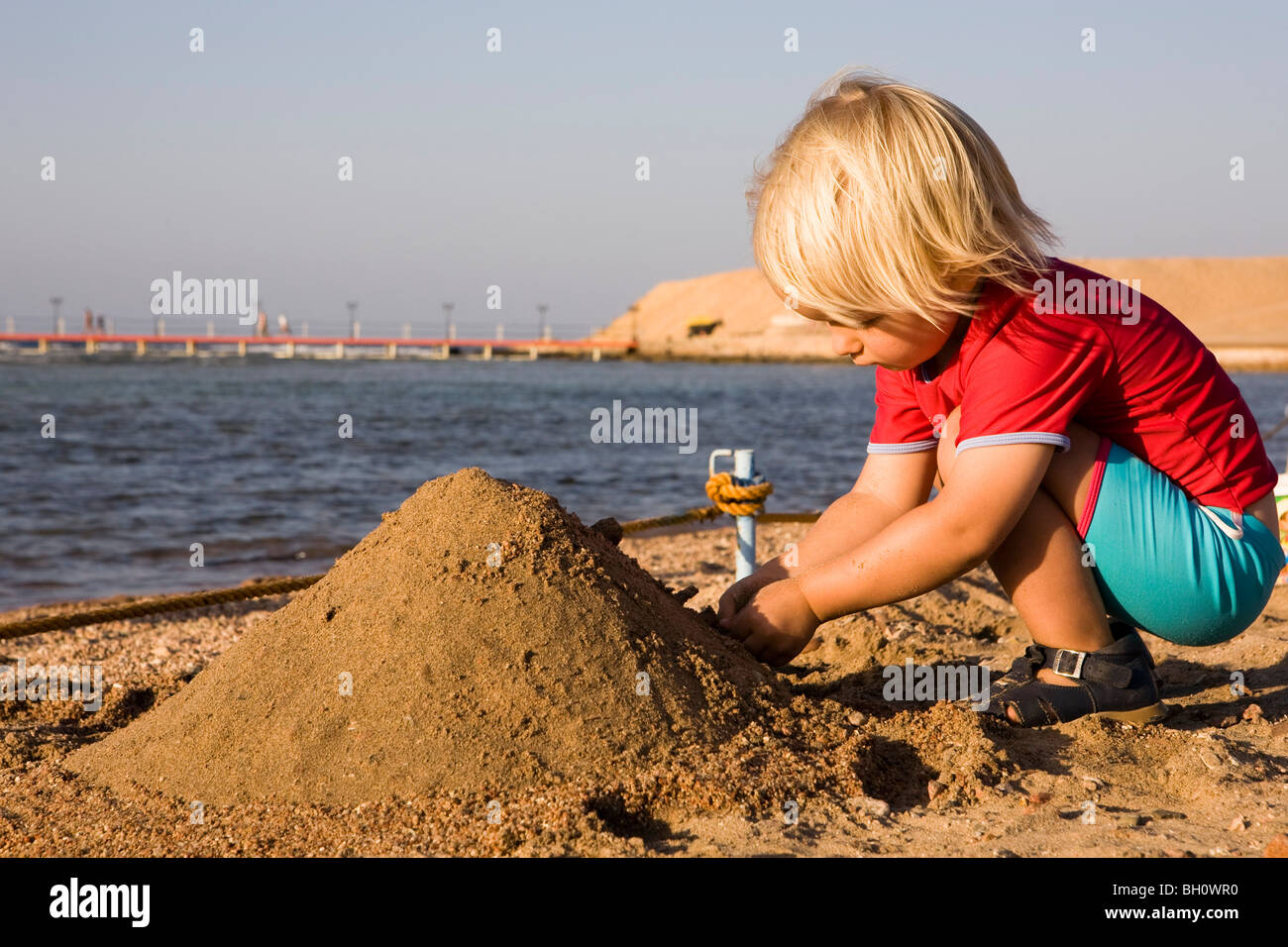 Kleines Kind, Mädchen, 3, spielen mit Sand am Strand von Lamaya Resort, Coraya, Marsa Alam, Rotes Meer, Ägypten Stockfoto
