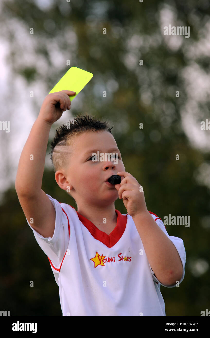 Kinder Fußball coaching Youngster zeigt gelbe Karte und Pfeife bläst Stockfoto