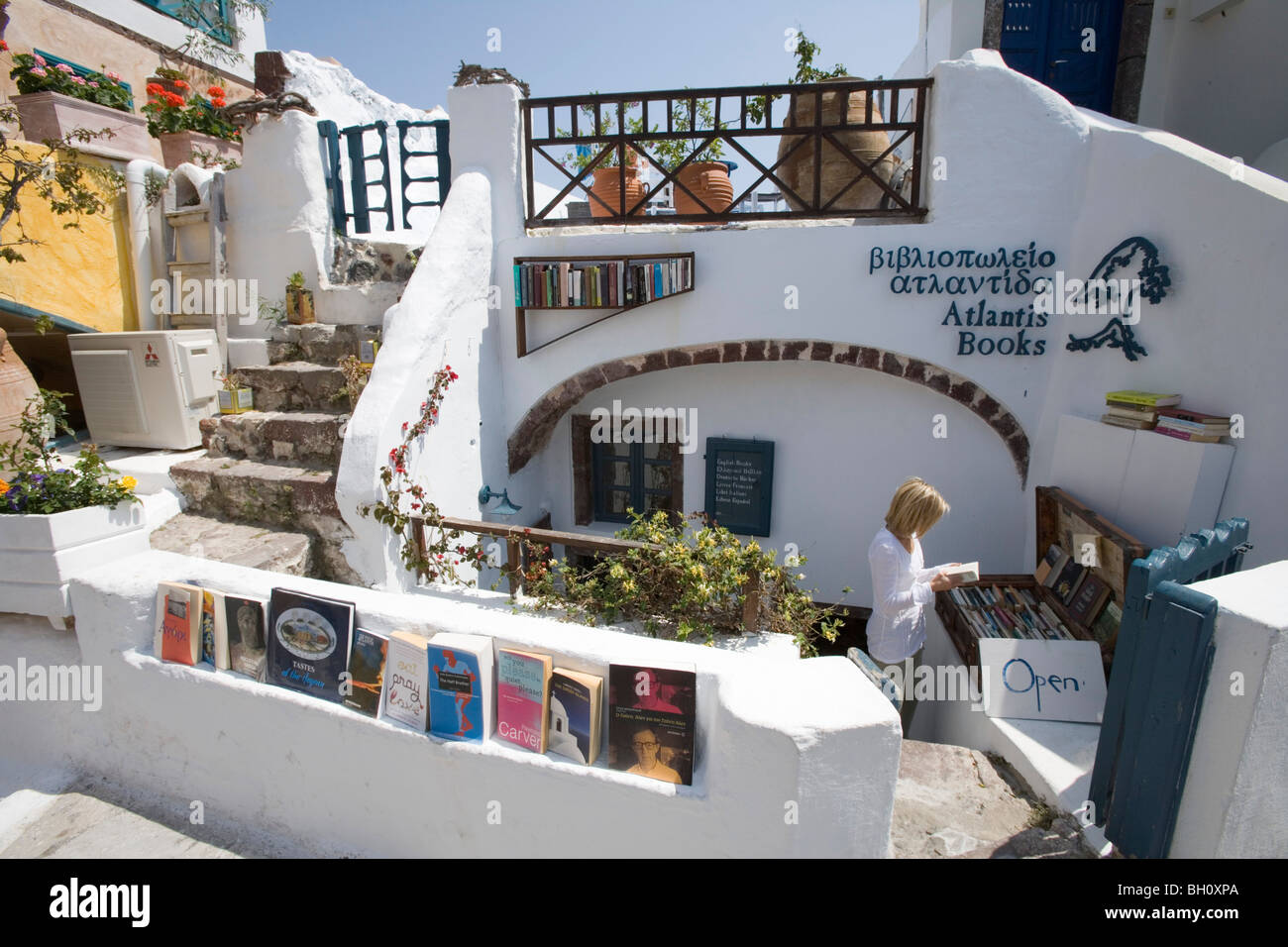 Frau in Atlantis Bücher Buchhandlung im Sonnenlicht, Oia, Santorini, Griechenland, Europa Stockfoto
