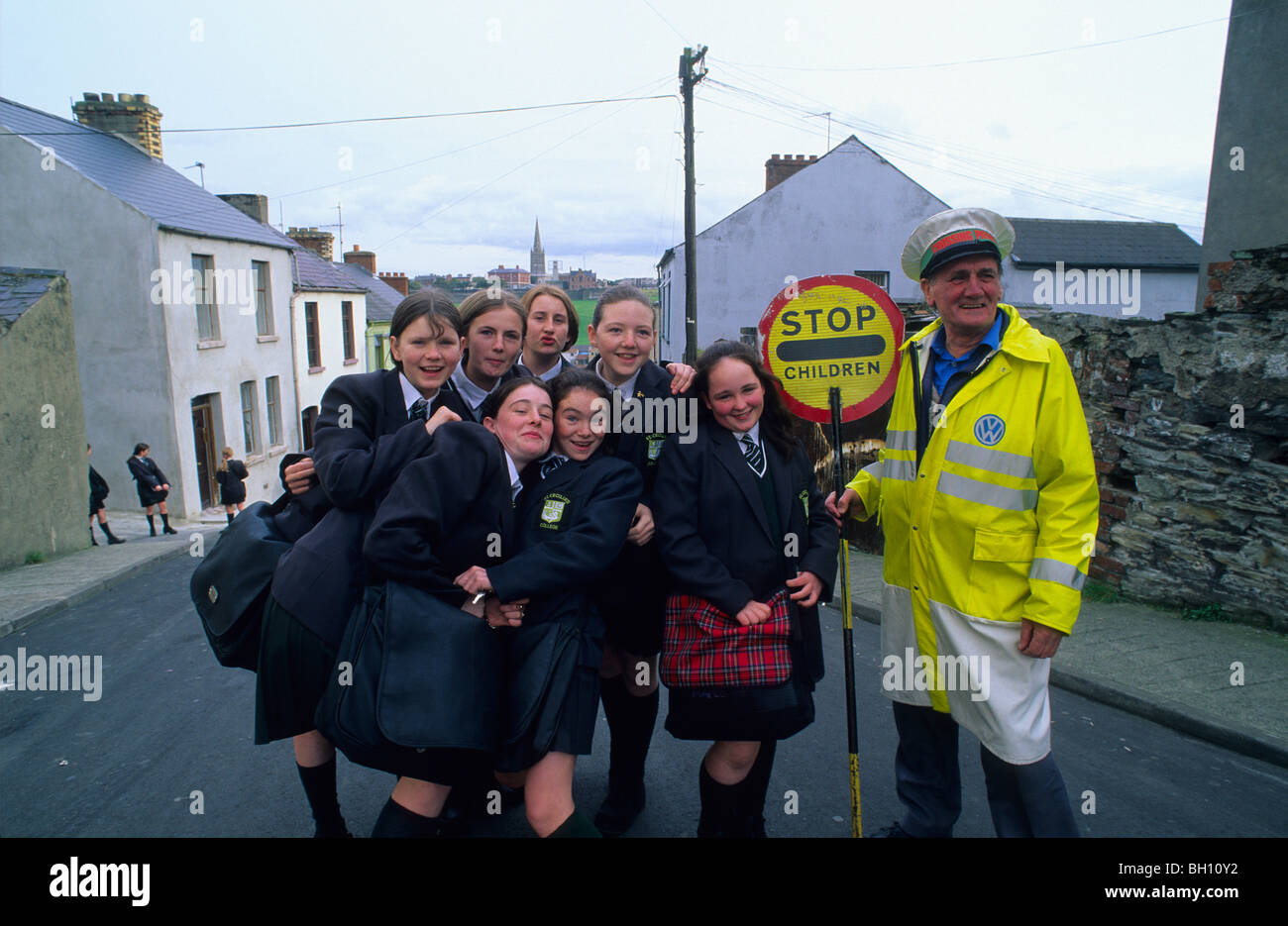 Schule Kreuzung Wache, Lollipop-Mann, mit Schulkindern, Bogside, Derry, Co. Londonderry, Nordirland, Vereinigtes Königreich, Eur Stockfoto