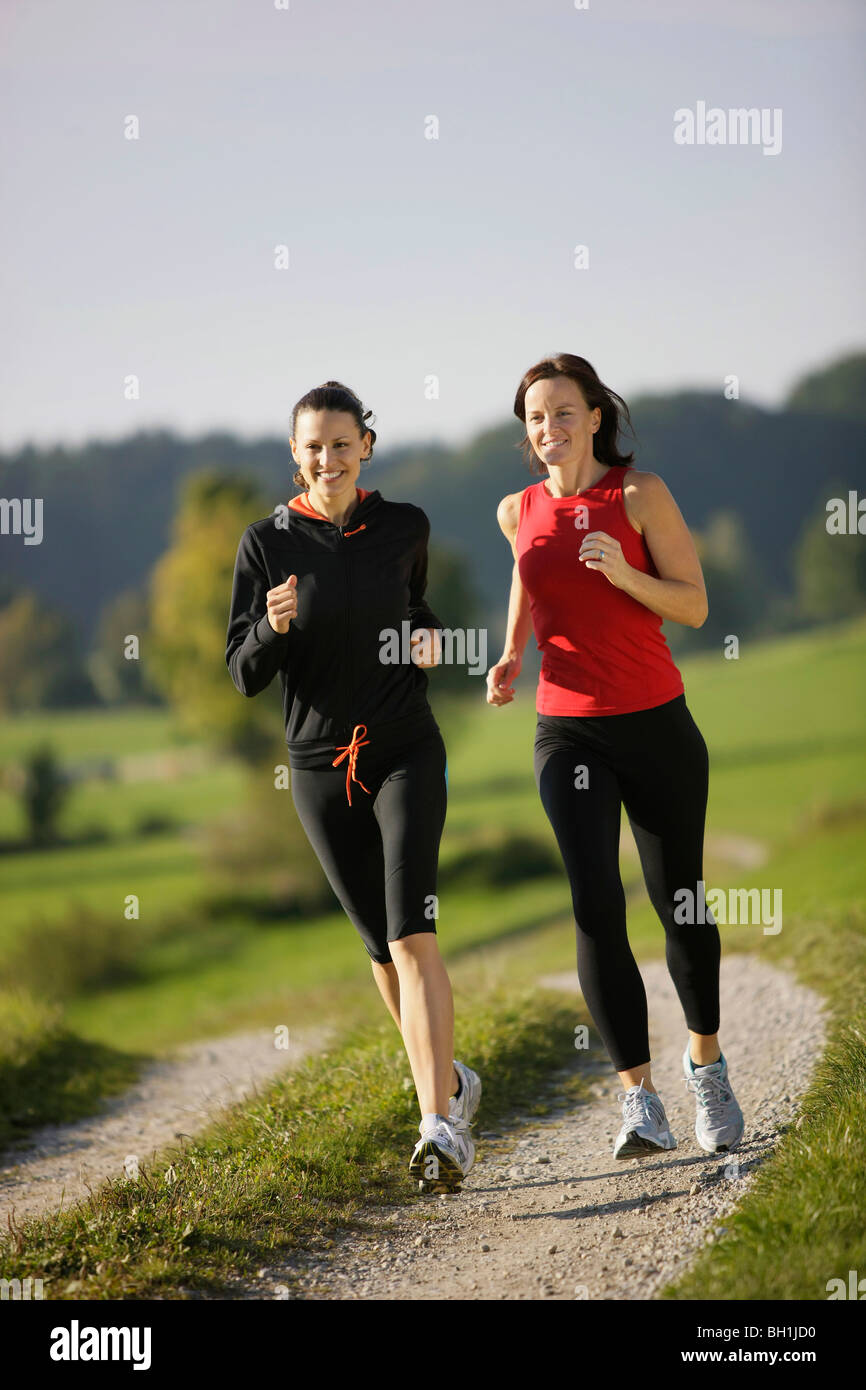 Zwei Frauen laufen auf Schotterweg, Munsing, Bayern, Deutschland Stockfoto