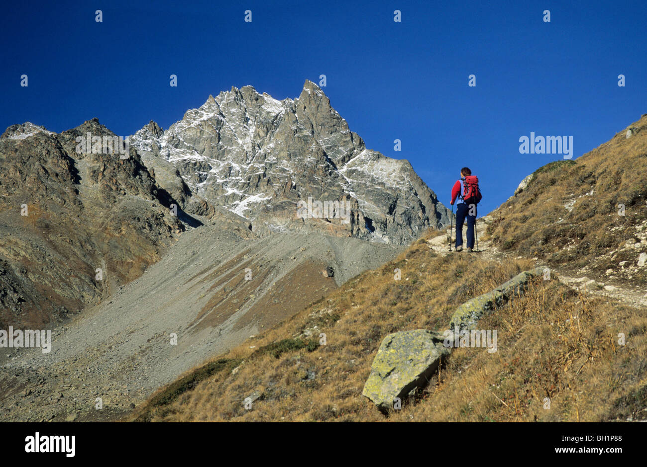 Junge Frau auf dem Weg bis zur Almhütte Chamanna Essen-Cha mit Piz Kesch im Hintergrund, Bereich Silvretta, Silvretta, Oberengadin, Stockfoto