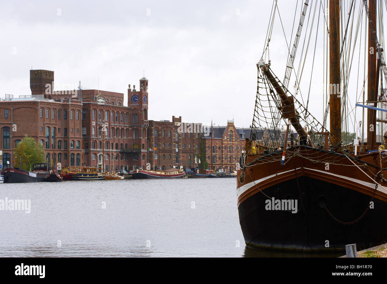 Ein Segelschiff auf dem Fluss Zaan vor Ziegel gesäumten Gebäuden, Wormerveer, Niederlande, Europa Stockfoto