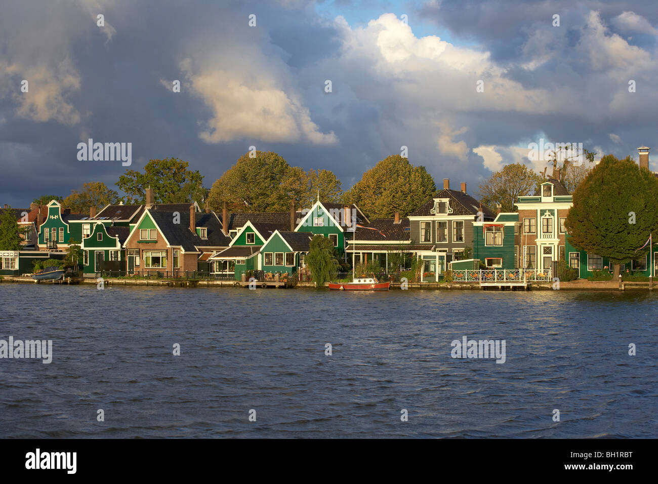 Historische Häuser am Fluss Zaan unter bewölktem Himmel in den Morgen, Zaandijk, Niederlande, Europa Stockfoto