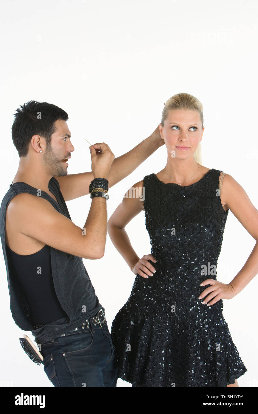Friseur macht Anpassungen, stehend mit Händen auf den Hüften zu modellieren Stockfoto