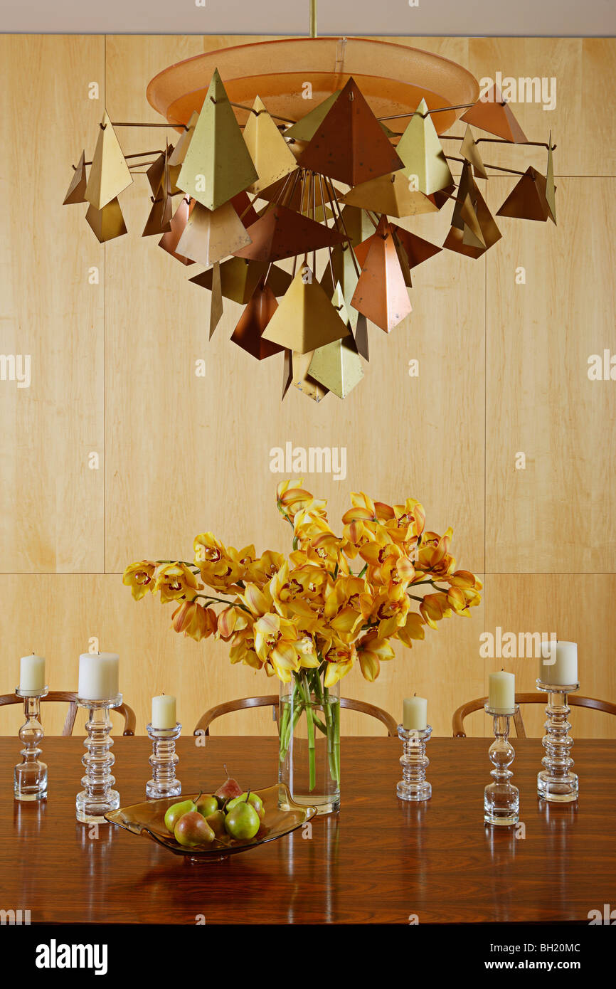 Metalworked Licht über dem Herzstück von Schnittblumen auf Tisch Stockfoto