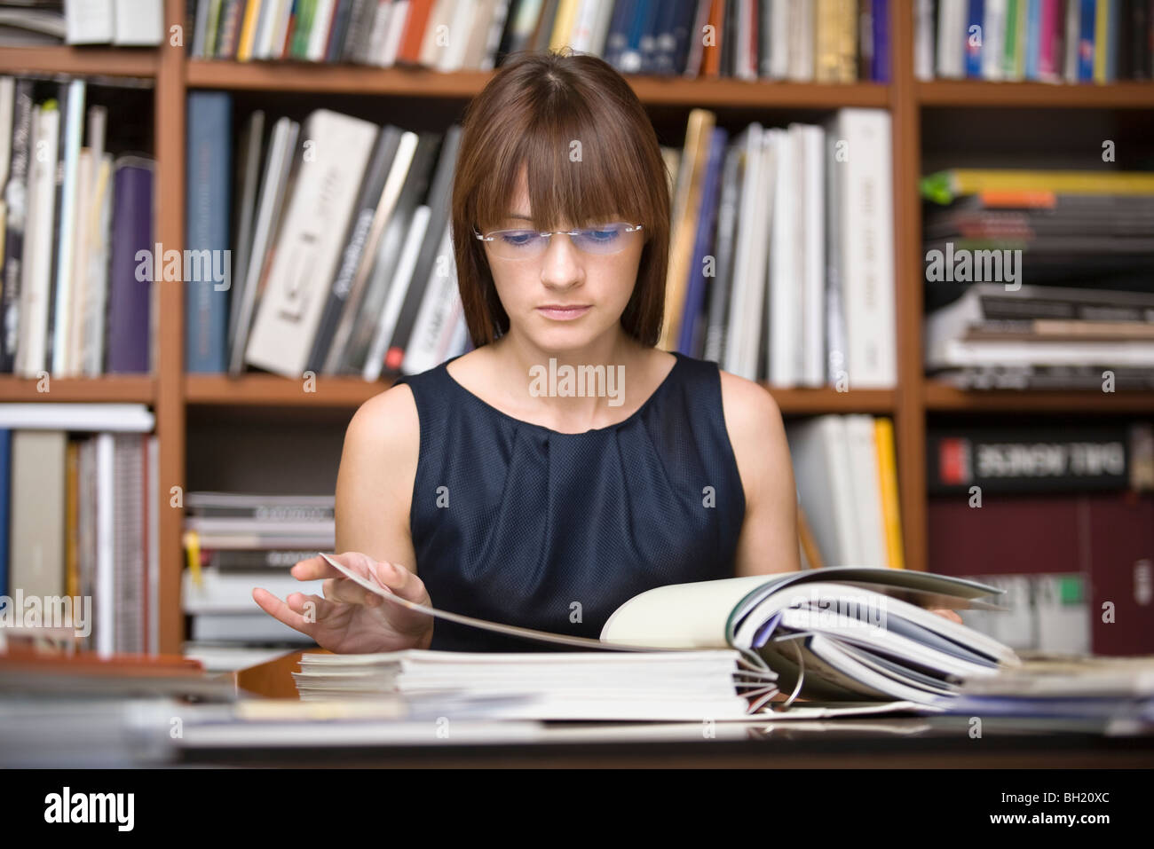 Junge Designer sitzt in der Bibliothek recherchieren Stockfoto