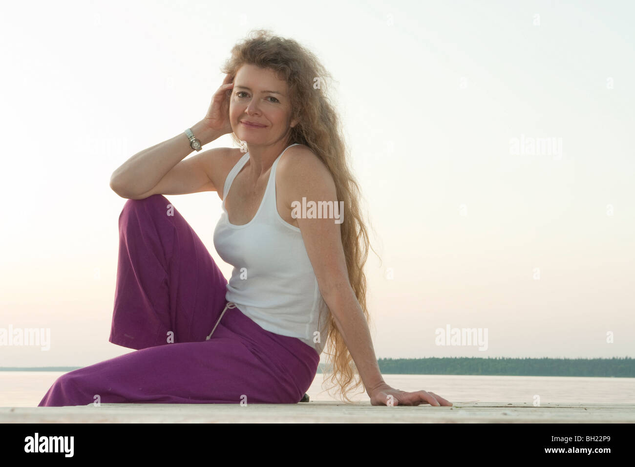 Frau sitzend auf Dock von Clear Lake, Manitoba, Kanada Stockfoto