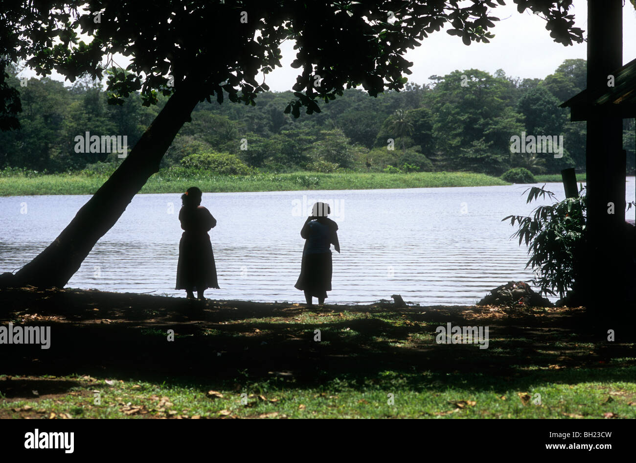Silhouetten von zwei Frauen stehen am Rand des Flusses, Tortuguero, Costa Rica Stockfoto Silhouetten von zwei Frauen stehen am Rand des Flusses, Tortuguero, Costa Rica Stockfoto