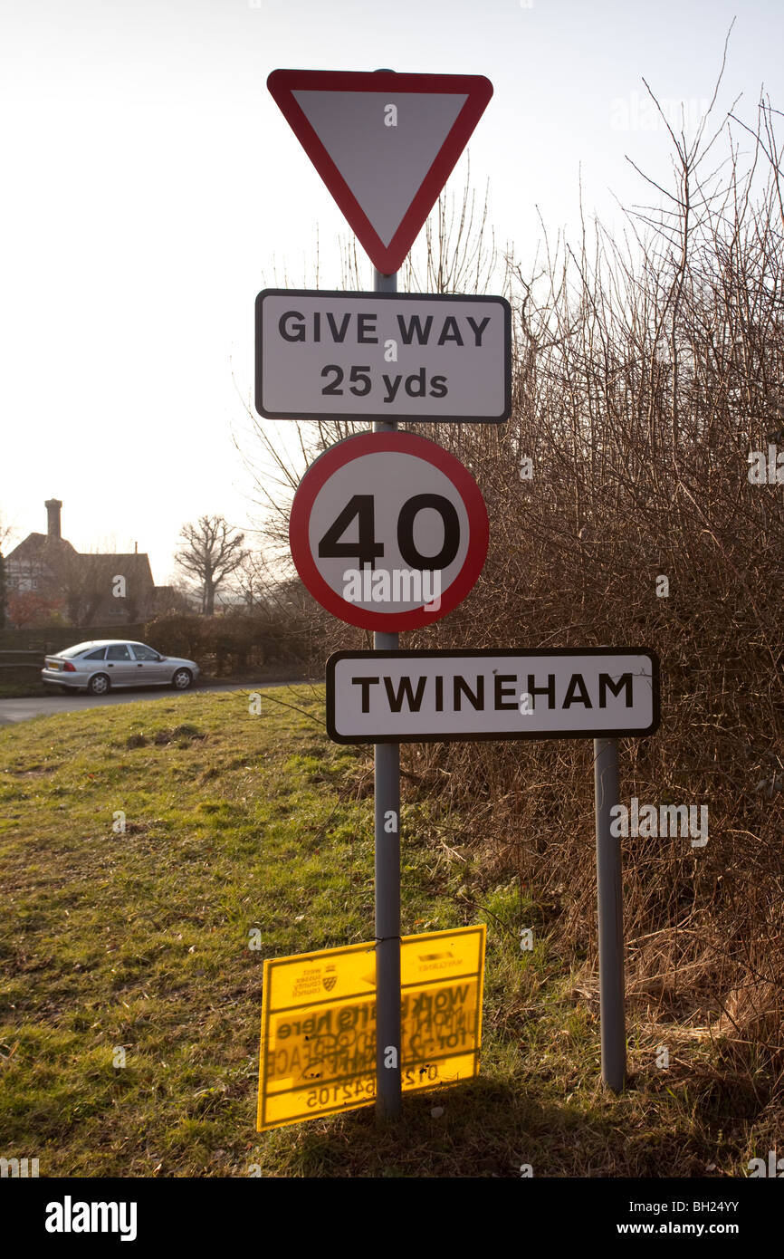 Ein Zeichen post mit mehreren Zeichen für Max Speed für Fahrzeuge, Vorfahrt an einer Kreuzung und Twineham Dorf Grenze. Stockfoto