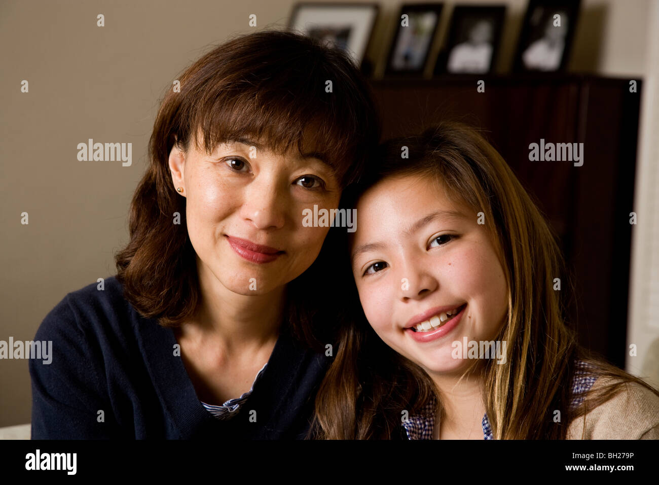 Koreanische Mutter und Koreanisch/weiß Tochter, warme Porträt zu Hause in ihrem Wohnzimmer. Stockfoto