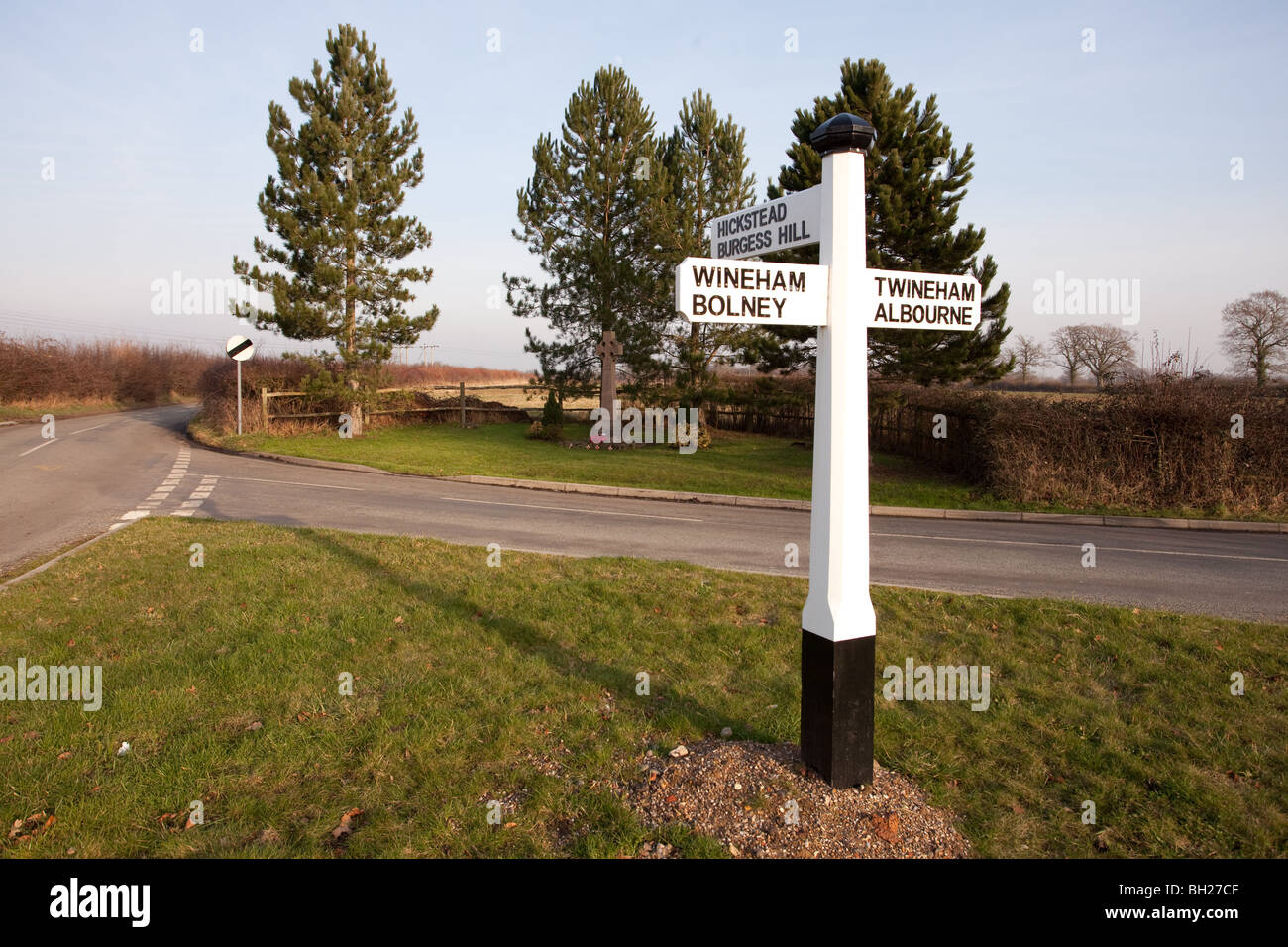Richtung Verkehrszeichen an der Sussex, Dorf von Twineham zusammen mit der Dorf-Gedenkstätte für die gefallenen Kameraden Stockfoto
