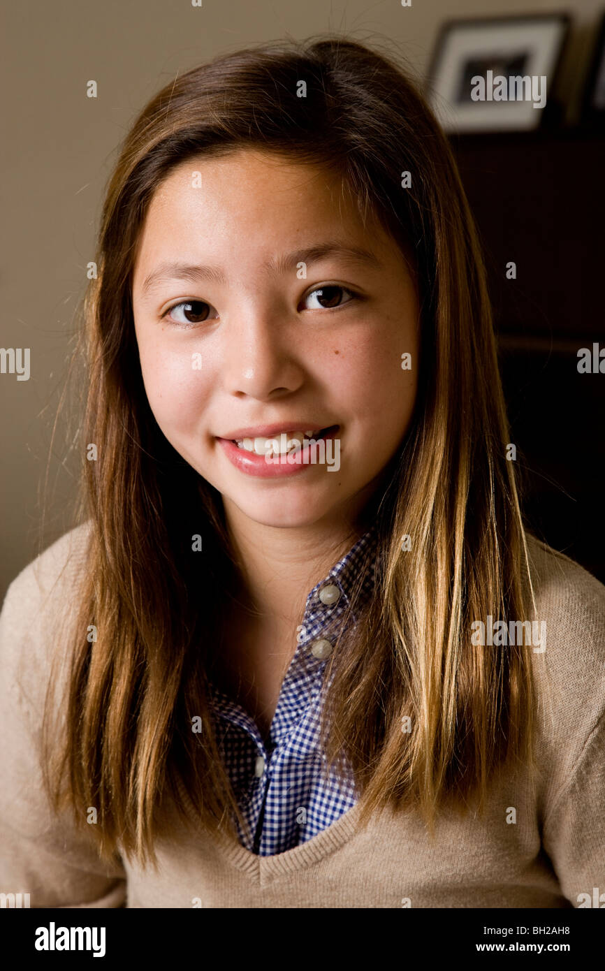 Fröhliches 11-jährige Koreanisch/weiß Mädchen lächelnd in die Kamera, Porträt. Stockfoto