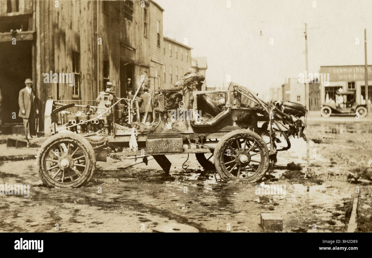 Hulk von verbrannten Tourenwagen auf Stadtstraße Stockfoto