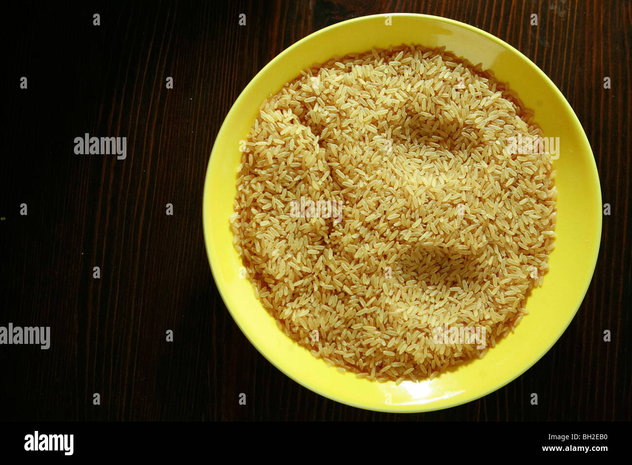 Gelbes Schild mit brauner Reis gefüllt zeigt einen traurigen Smiley Stockfoto