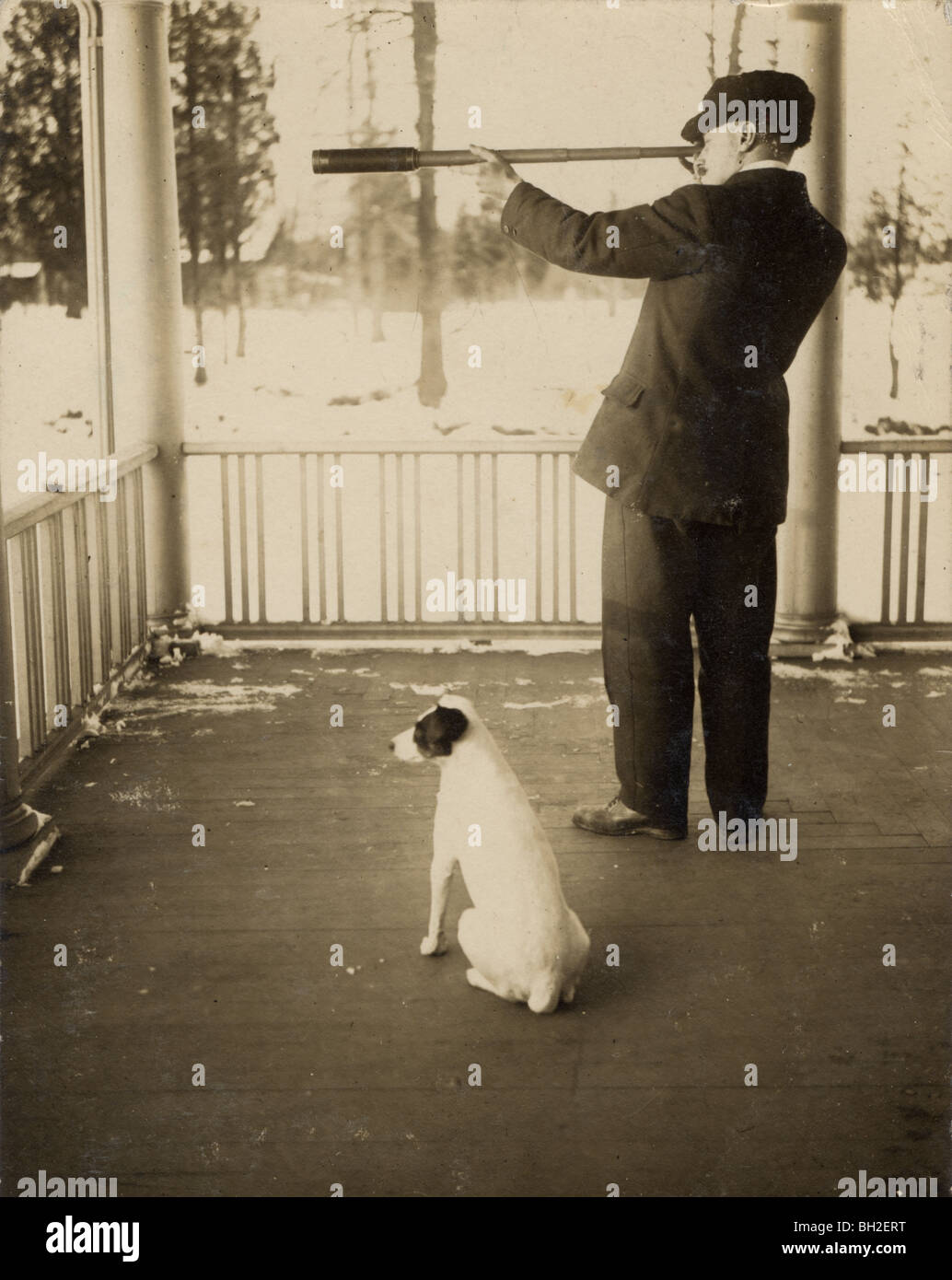 Mann mit Hund anzeigen durch Teleskop auf seiner Veranda Stockfoto