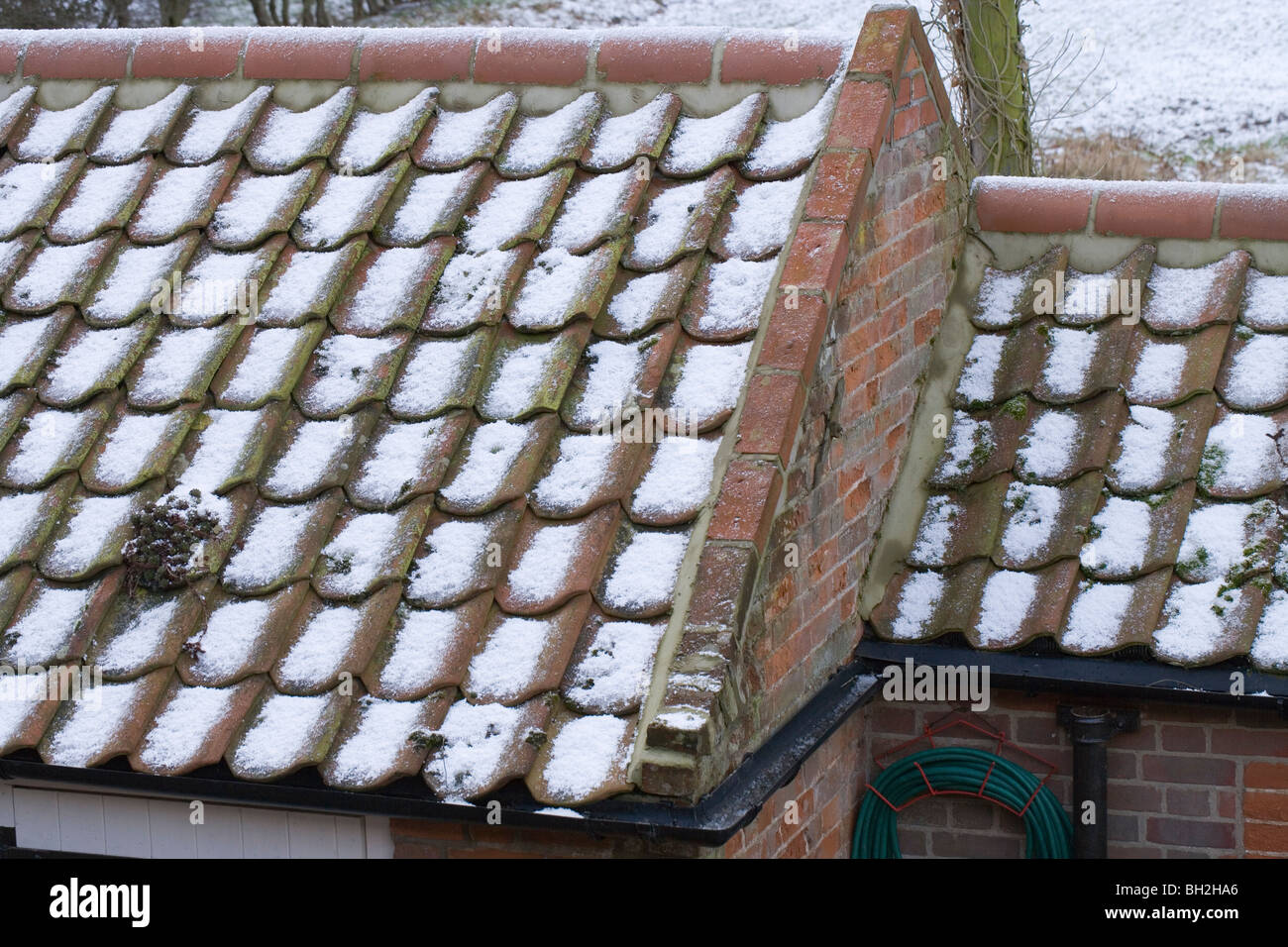 Schnee und Hagel Steinen auf Flachdachziegel Dach von einem Nebengebäude. Stockfoto