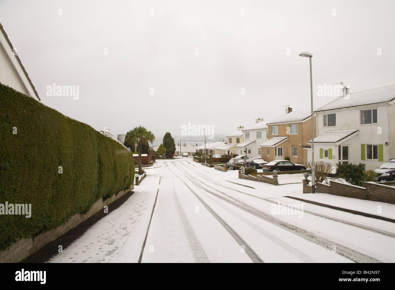 Benllech ISLE OF ANGLESEY Wales UK Januar Ungewöhnlich verschneite Straße Gärten und Häuser in diesem Dorf am Meer Stockfoto