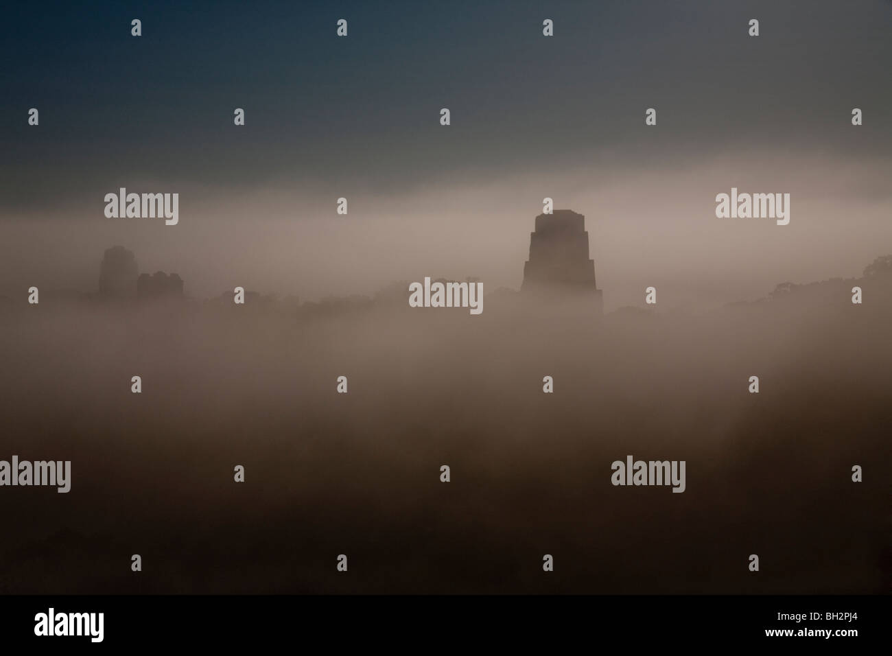 Sunrise und frühen Morgennebel am Tikal Archäologie Standort. Stockfoto