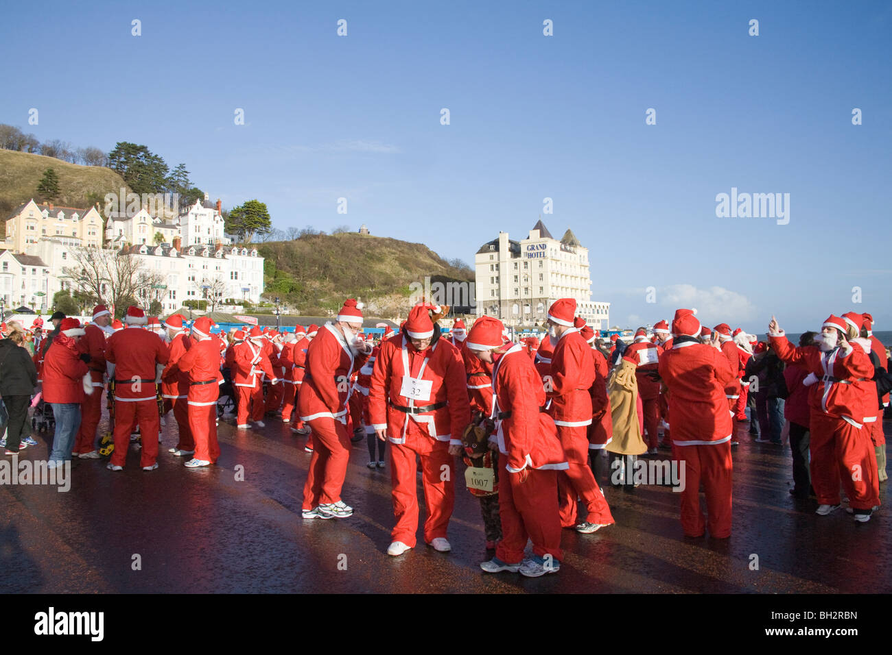 Llandudno North Wales UK Dezember Teilnehmer in der jährlichen Santa laufen für einen guten Zweck Schlange auf der promenade Stockfoto