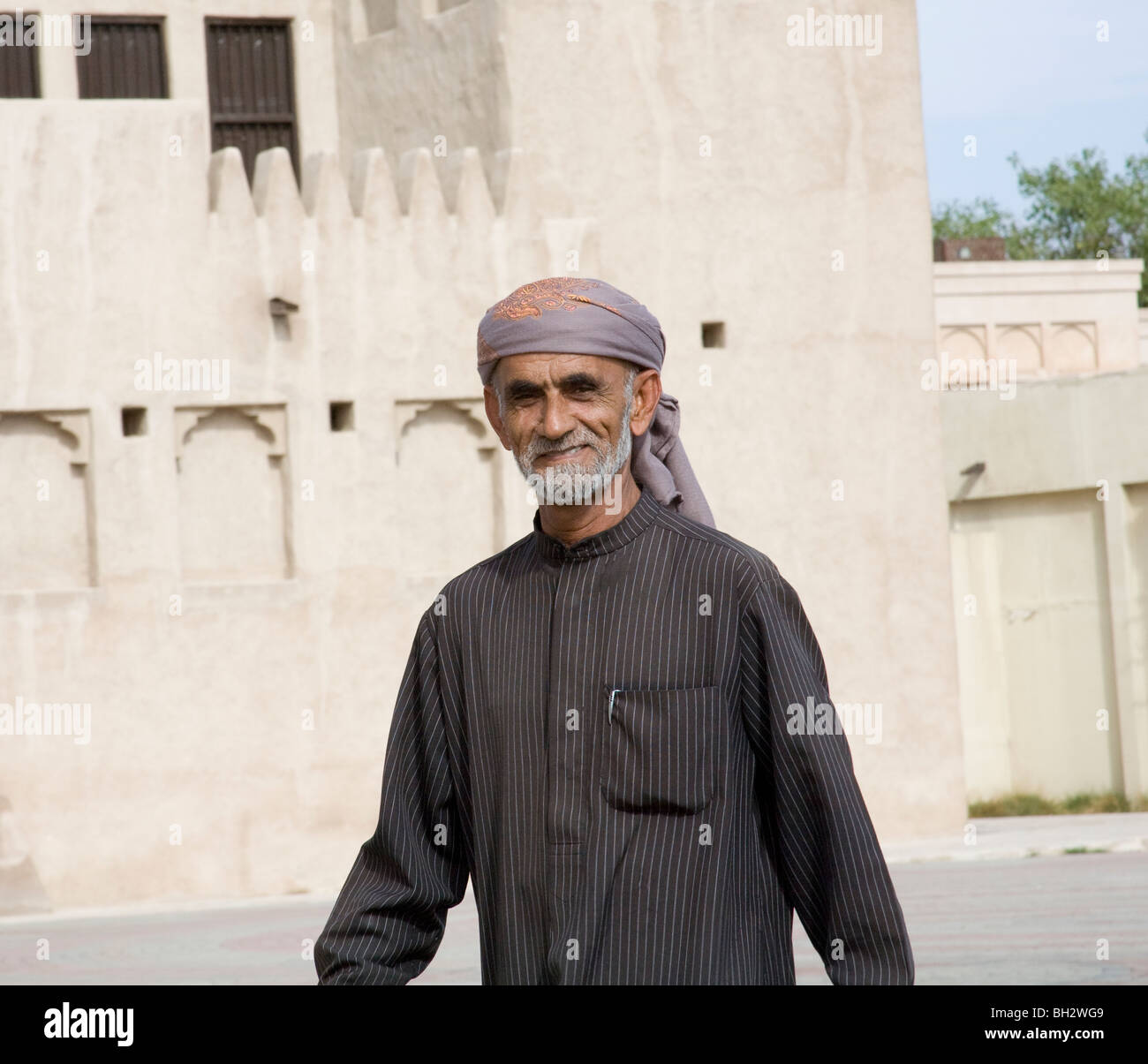 Dubai Vereinigte Arabische Emirate älteren arabischen Mann trägt eine Pin gestreift Thobe und lila und Orange Kufiya Stockfoto