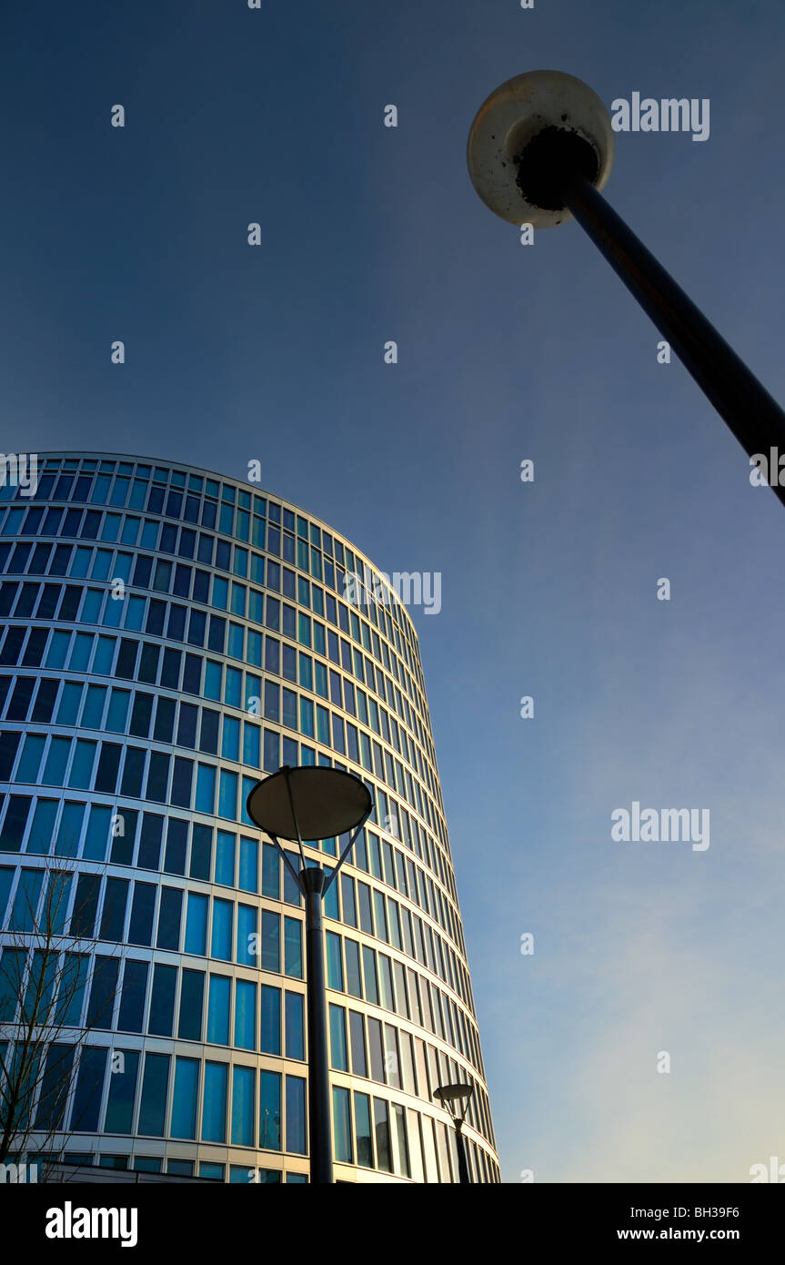 Moderne abstrakte Sicht eines Hochhauses von Wohnungen oder Büros gegen eine Skyline mit Lampe Beiträge im Vordergrund Stockfoto