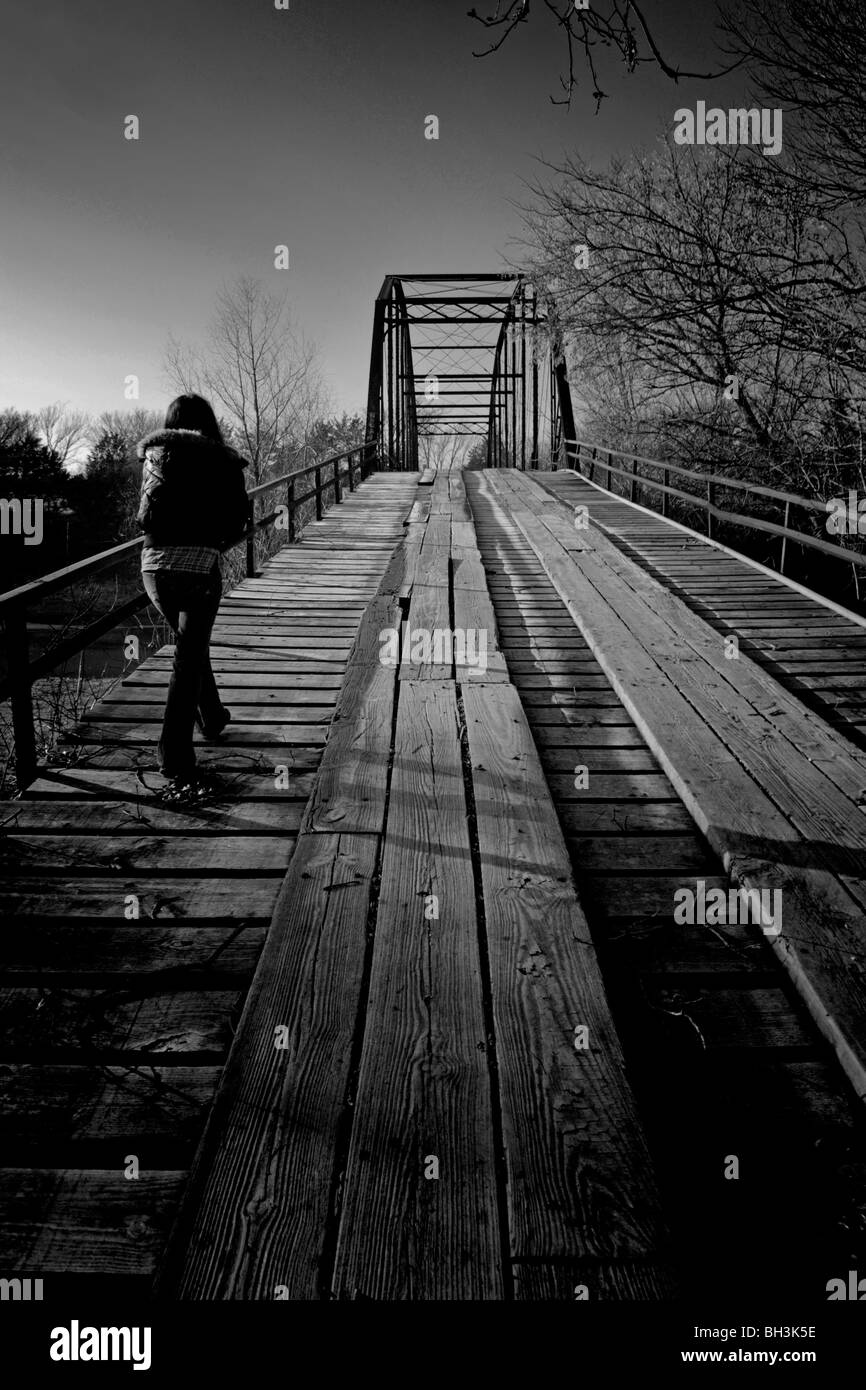 Lady mäandernden entlang einer alten verfallenen antiken Brücke von gestern scheint an diesem frostigen Morgen entmutigt sein Stockfoto