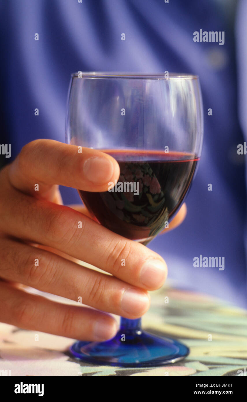 Mann hält ein Glas Rotwein Stockfoto