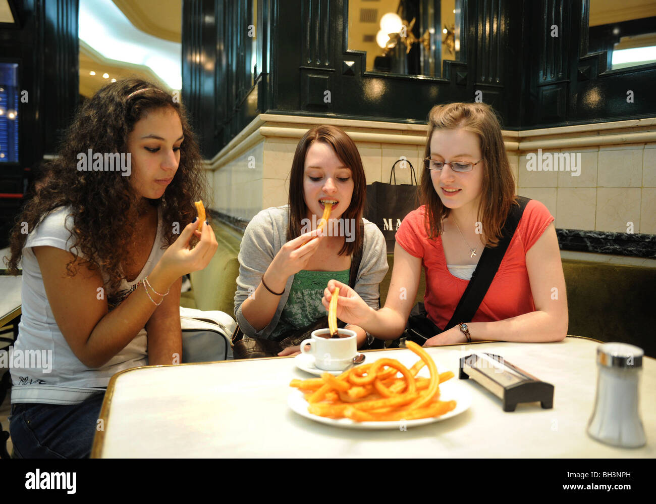 Mädchen essen Churros in der Schokolateria San Gines in Madrid, Spanien Stockfoto